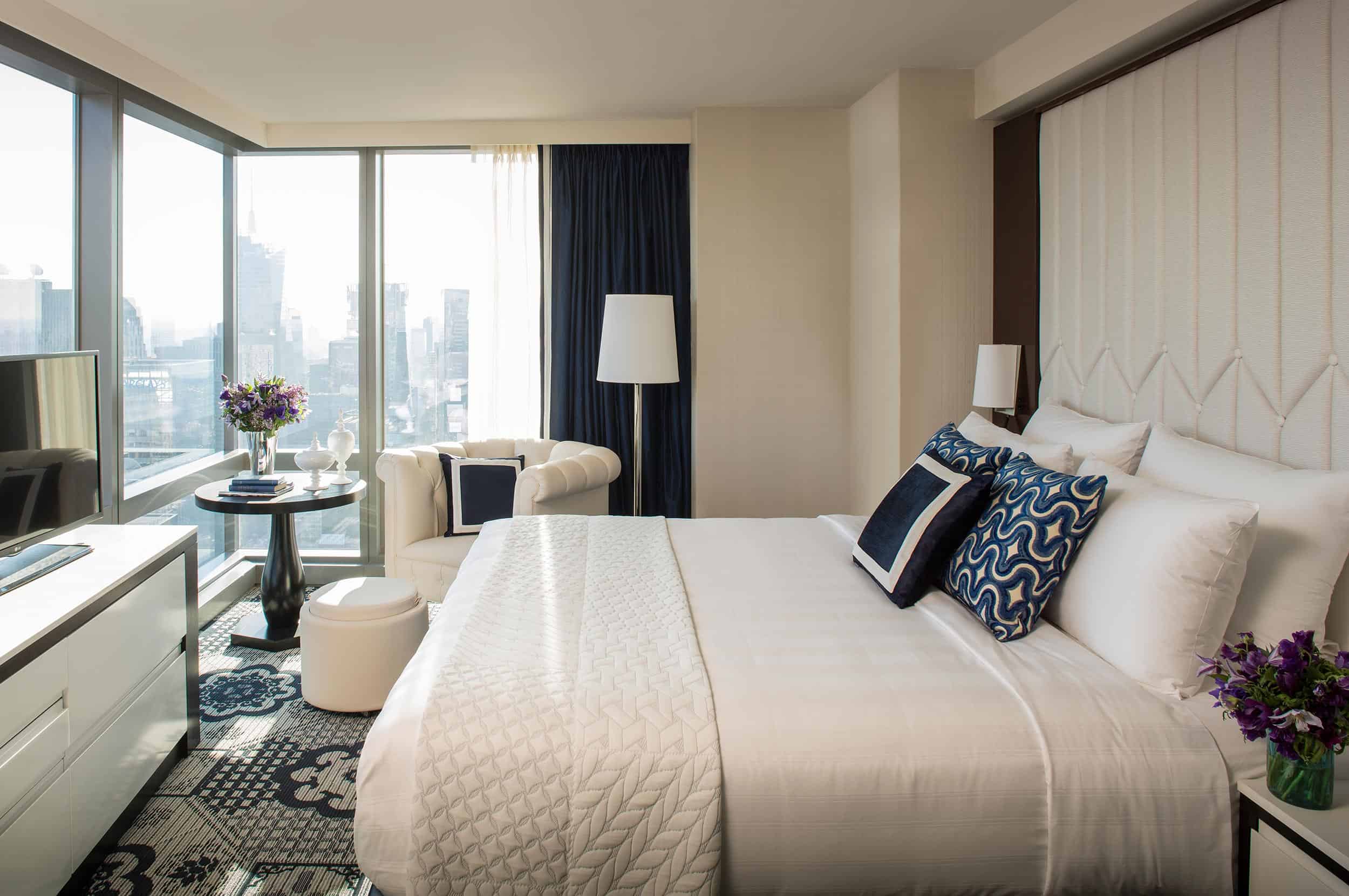 Corner room with king-size bed, reading nook and floor-to-ceiling windows overlooking the city